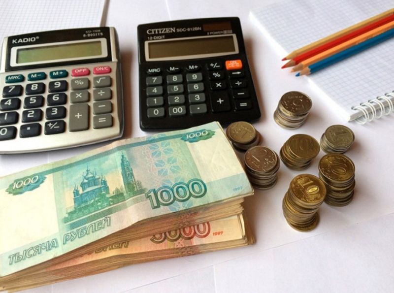 Два калькулятора и денежные купюры на столе